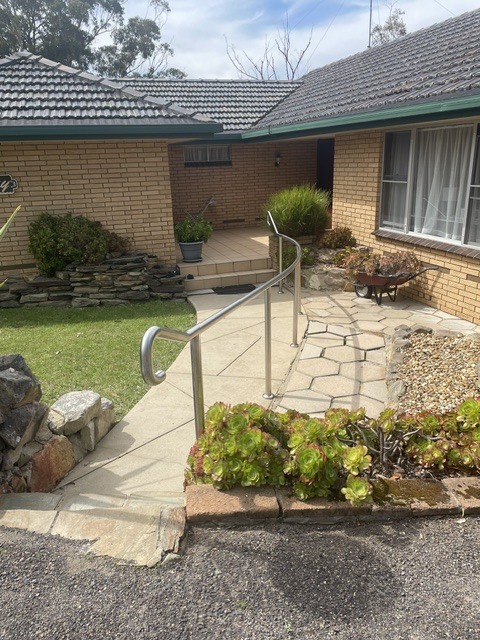 Front of the property with the entry path, handrail and lawn